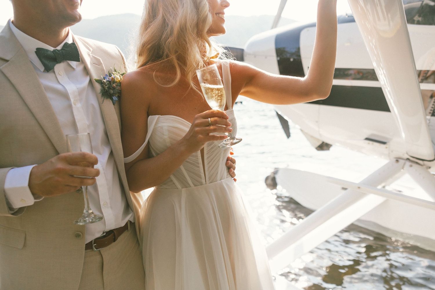 Couple in formal attire toasting with champagne on a boat.