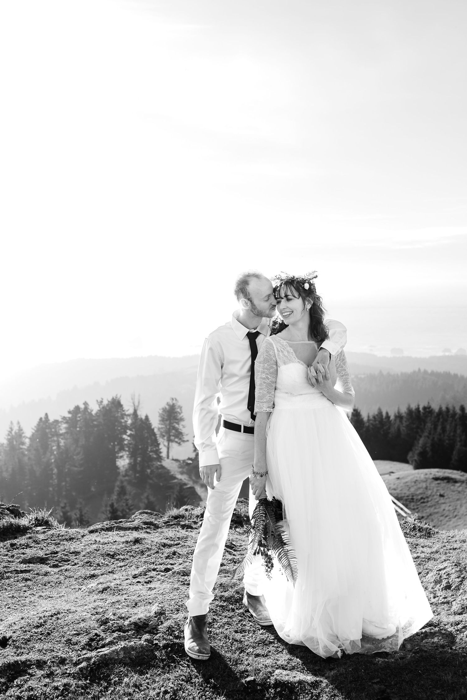 Bride and groom snuggle close while getting wedding photos taken by Taylor Carpenter Photography along lovely coastal backdrop