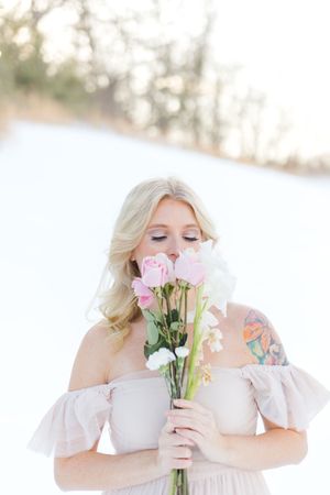 woman in a dress in snow with flowers in Culpeper Virginia