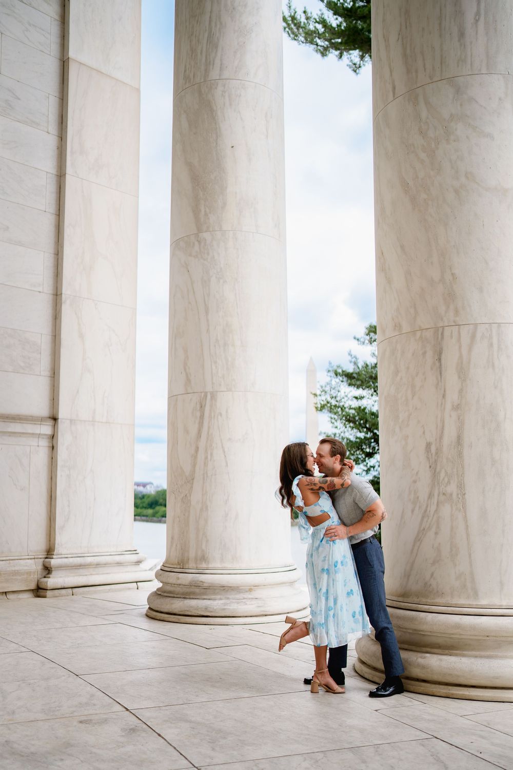 Couple sharing a romantic kiss among grand marble columns at the Jefferson Memorial in Washington D.C.