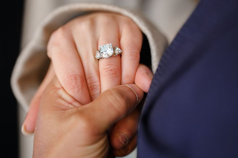 Close-up shots of hands wearing wedding rings and engagement rings during a proposal session in Olney, MD