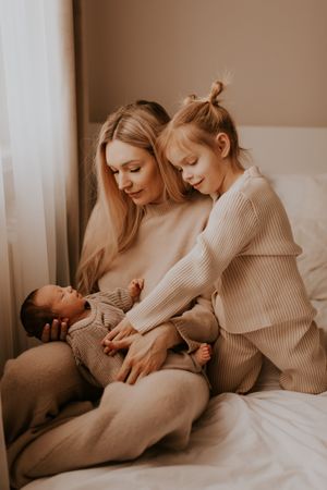 Tender family bonding moment on bed wearing matching knit sweaters.