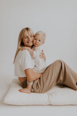 Cozy lifestyle portrait session with relaxed poses on white floor.