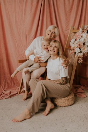 Casual family lifestyle photos against pink backdrop showing playful interactions on floor.