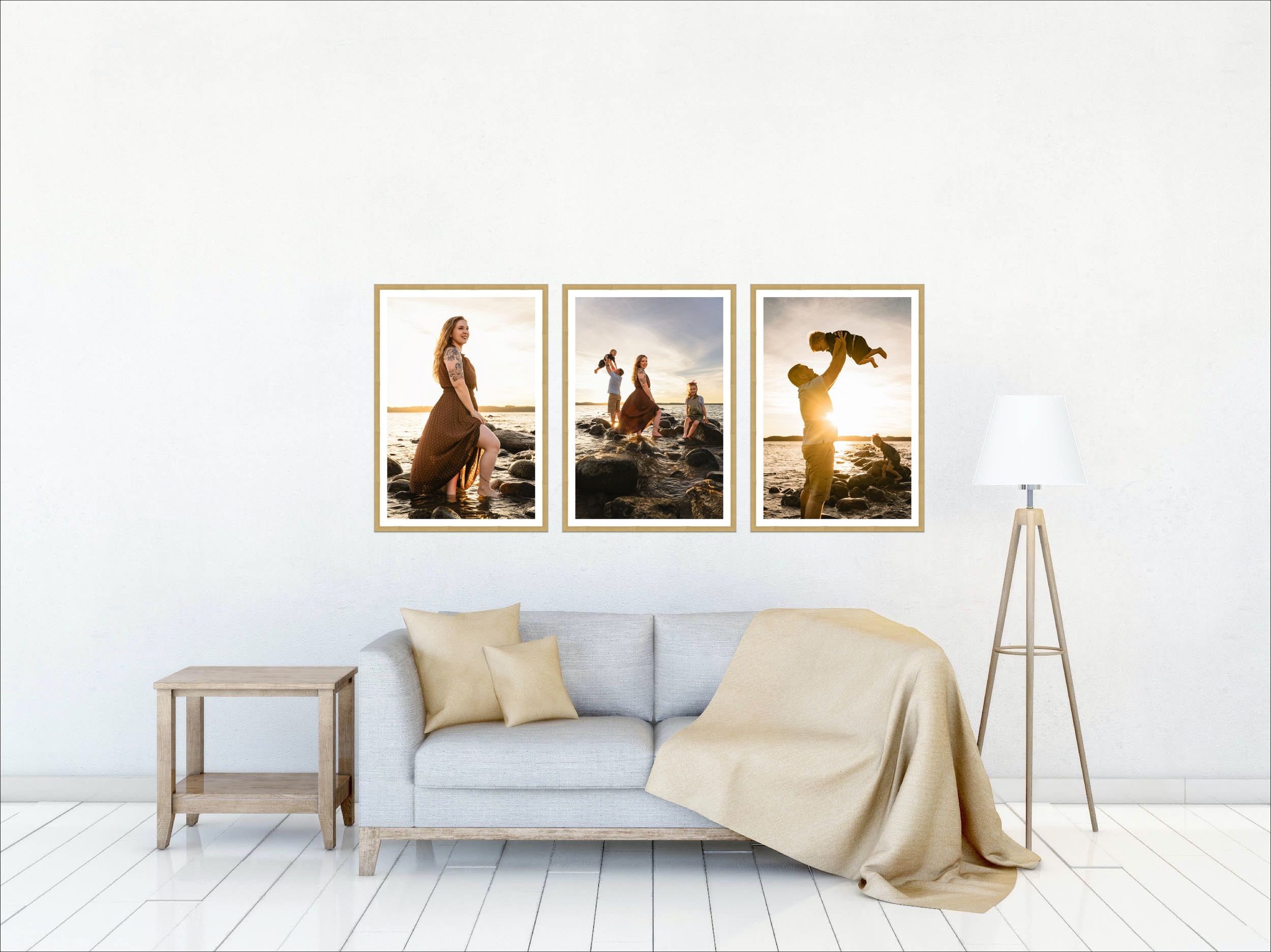 Three framed artwork prints hang above a modern beige sofa with throw pillows in a bright white living room interior.