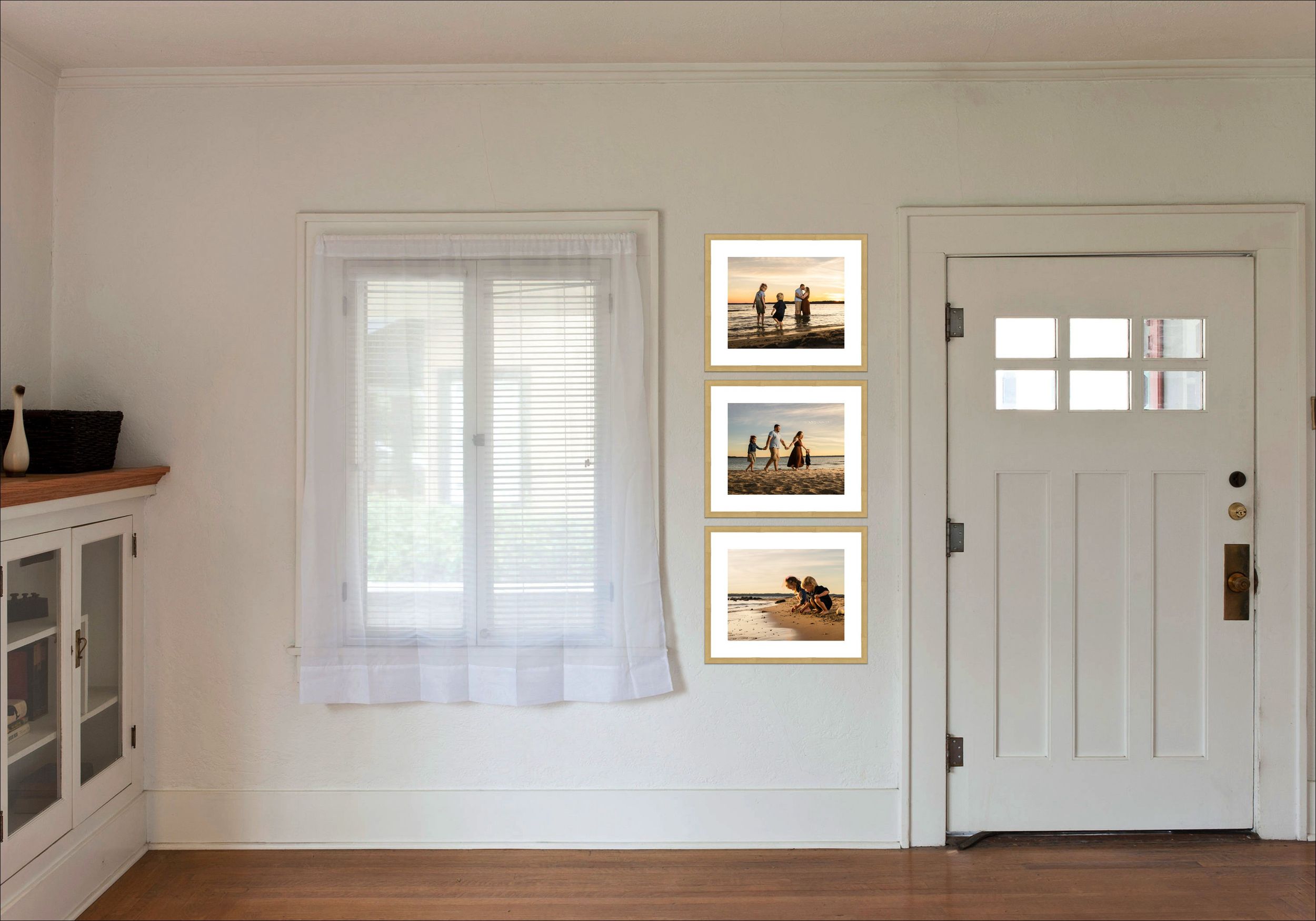 Bright white interior entryway with framed boat photos, craftsman door, and sheer curtained window.
