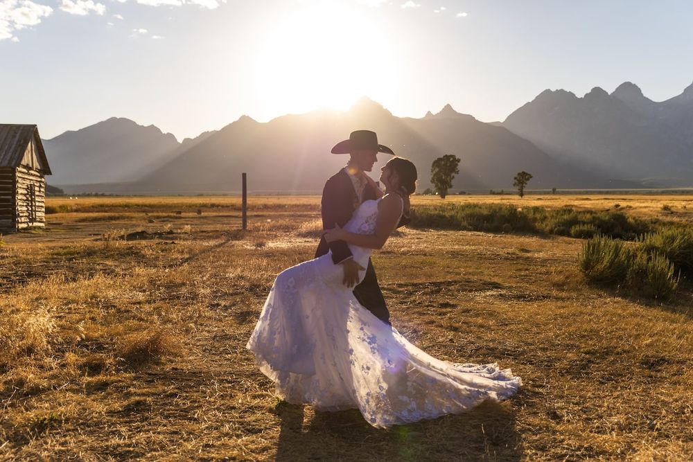 Dreamy mountain wedding photoshoot at sunset with silhouettes against golden light in Wyoming's Grand Teton range.
