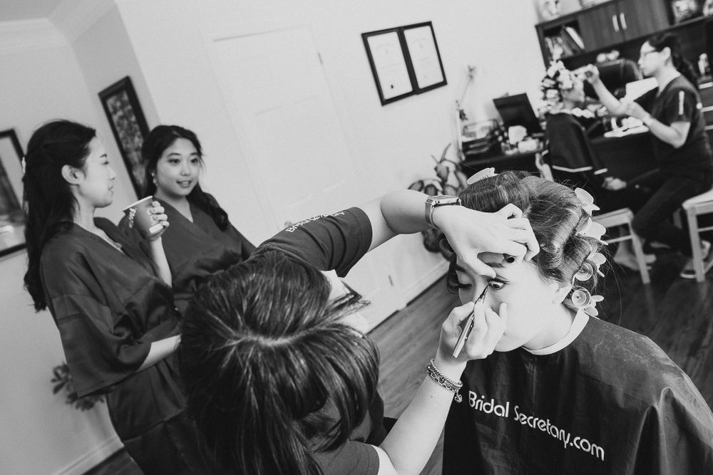 Behind-the-scenes shot of pre-wedding hair and makeup preparations in a salon.