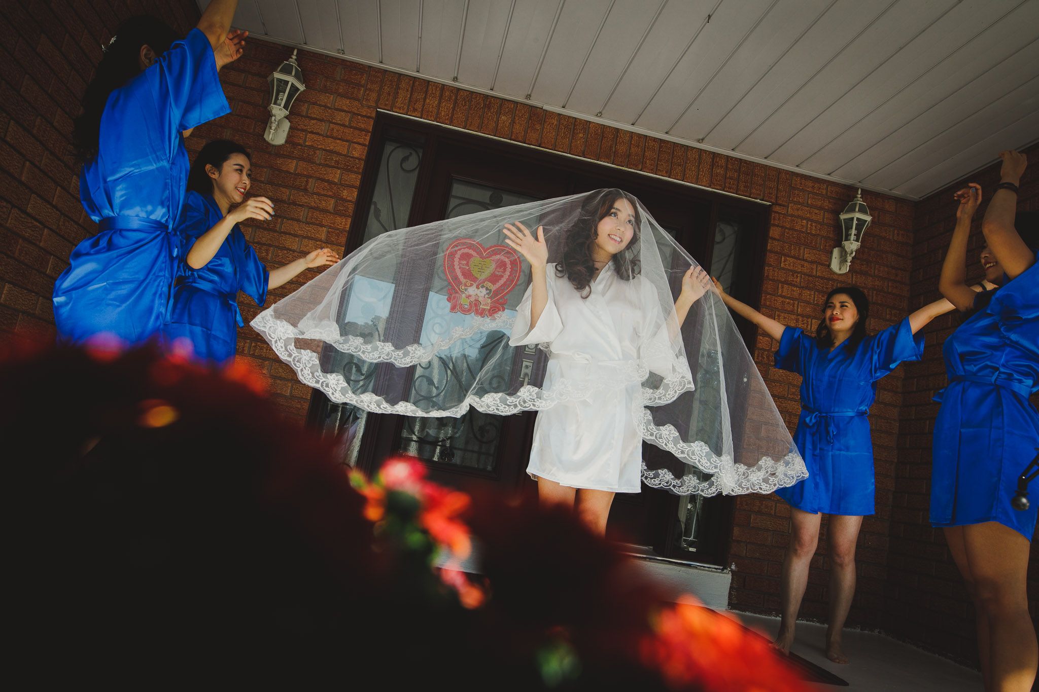 Wedding party scene with bride in white dress and bridesmaids in blue dresses dancing.