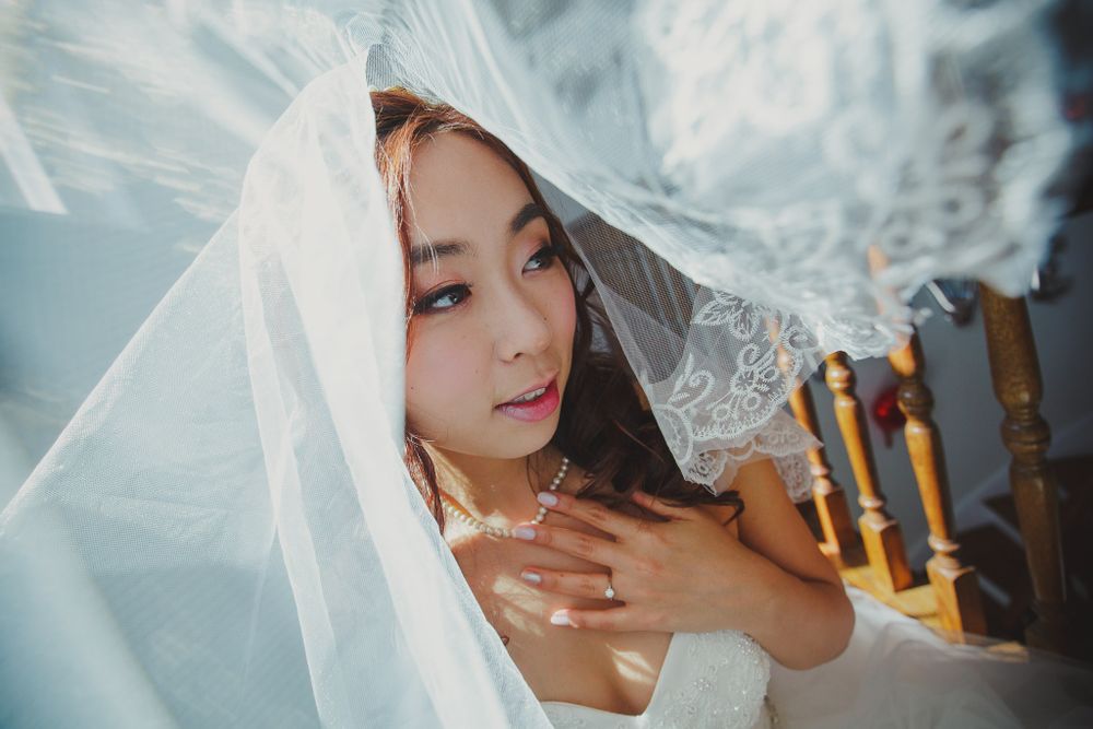 Artistic close-up shot through delicate white wedding veil lace.