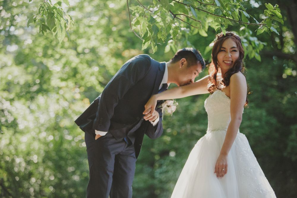 A couple shares a playful moment outdoors during their wedding photoshoot.
