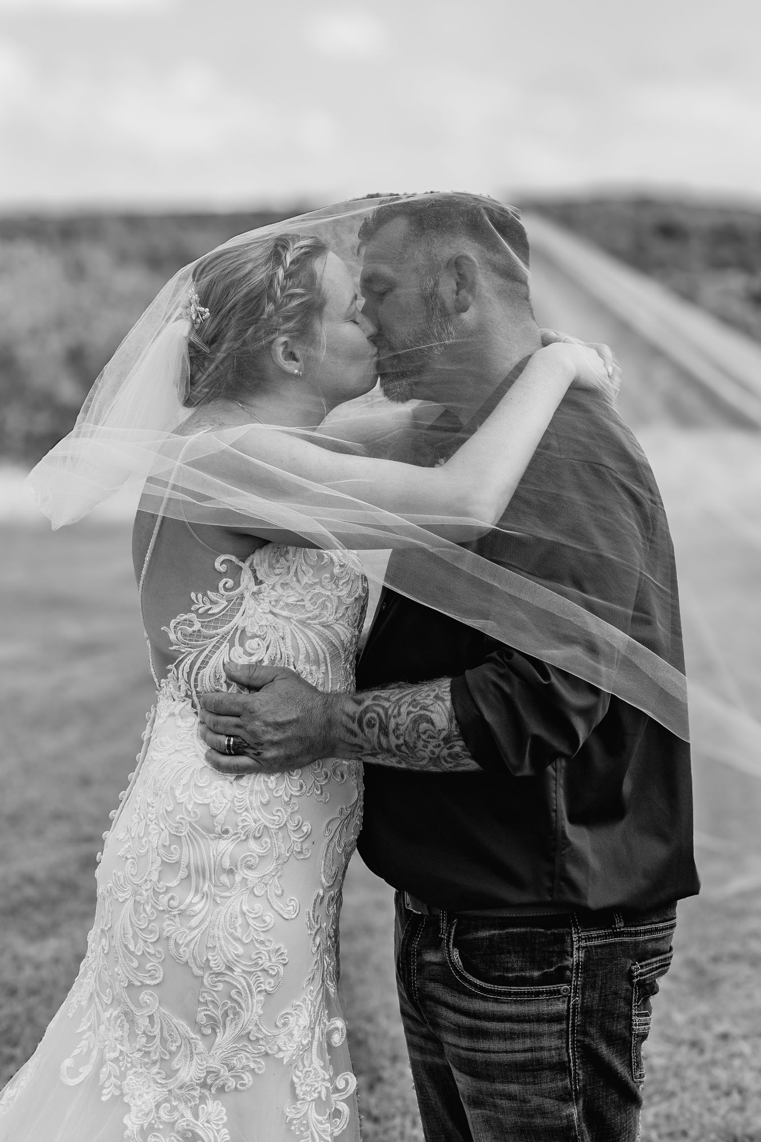 A bride and groom kissing under the bride's veil