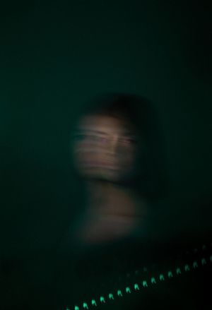 Blurred green lights create an abstract pattern in darkness.