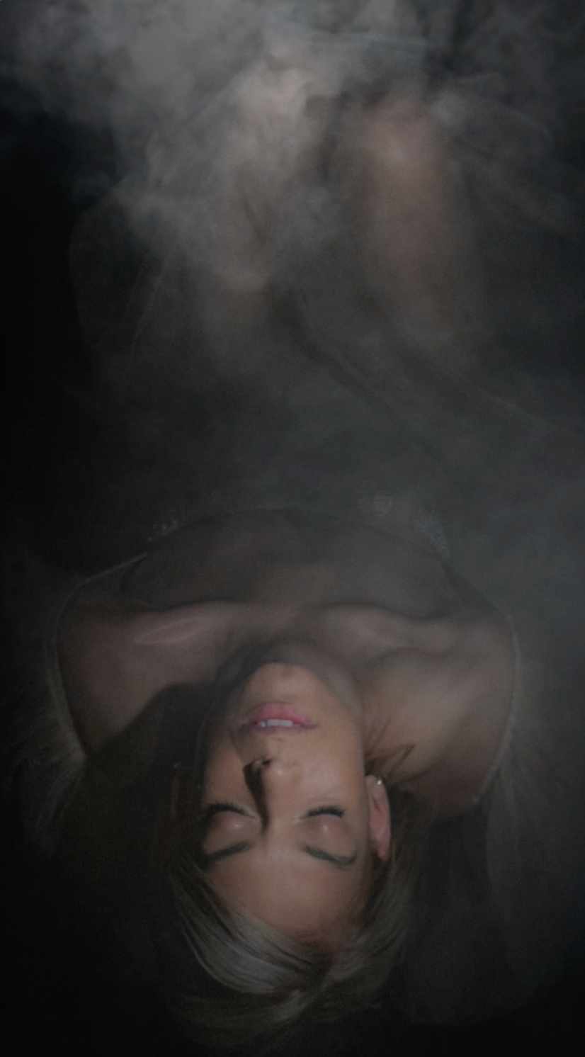 Ethereal portrait surrounded by dark smoke creating mysterious atmosphere.