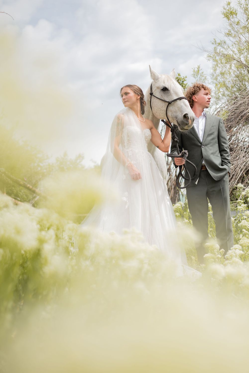 Soft focus wedding photography through spring foliage creates a dreamy atmosphere.