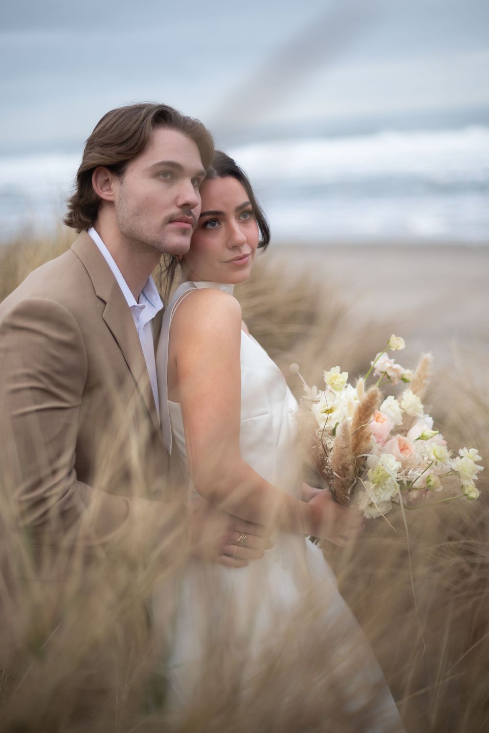 Romantic portrait in tall grass with soft focus and cream colored florals.