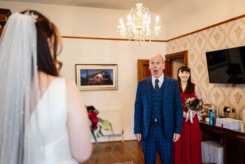 Father of the bride reacts seeing daughter in wedding dress at west tower exclusive wedding venue by Lynette Matthews Photography