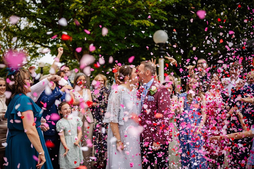 A wedding with pink, red & white heart confetti showering the wedding guests gathered outdoors at Southport Town Hall - Lynette Matthews