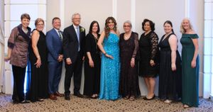 Formal group photo of people in evening attire at a special occasion.