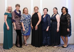 Group photo of women in formal dresses at an elegant event.