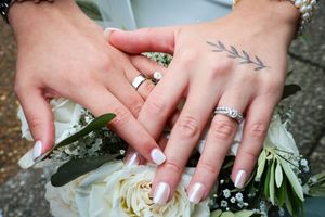 Close-up shots of wedding rings and bridal jewelry details with white flowers.