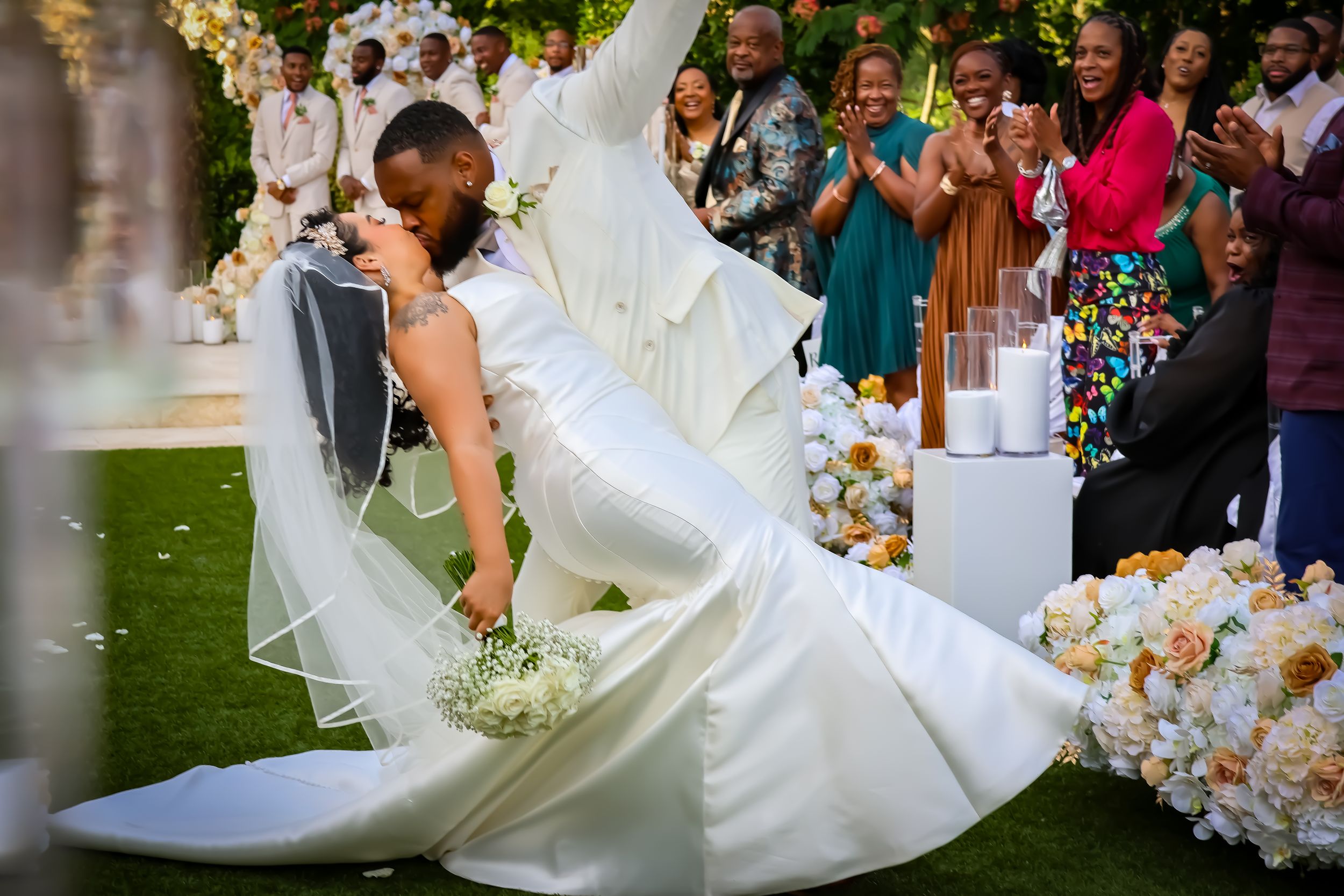 Wedding celebration with flowing white dress and floral arrangements.