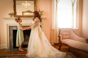 Elegant bridal portraits in pink room with chandelier and antique furniture.