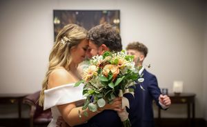 Wedding reception candid moments captured in warm indoor lighting with floral arrangements.