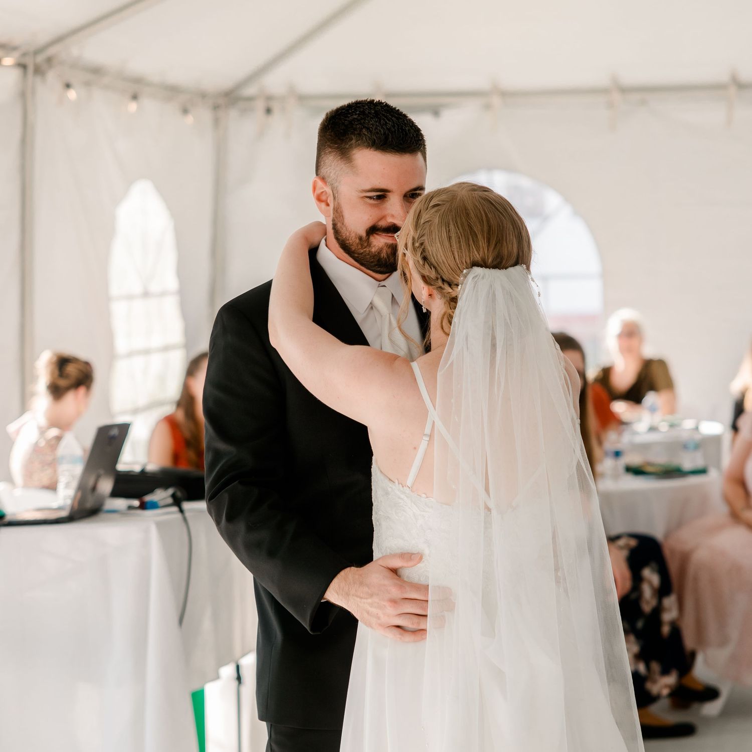 Husband and wife on their wedding day, joined together for a portrait shot. Bride's veil comes from left side of image.