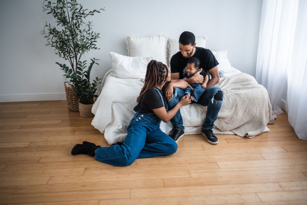 Candid sequence showing tender family moments on hardwood floor with white decor.
