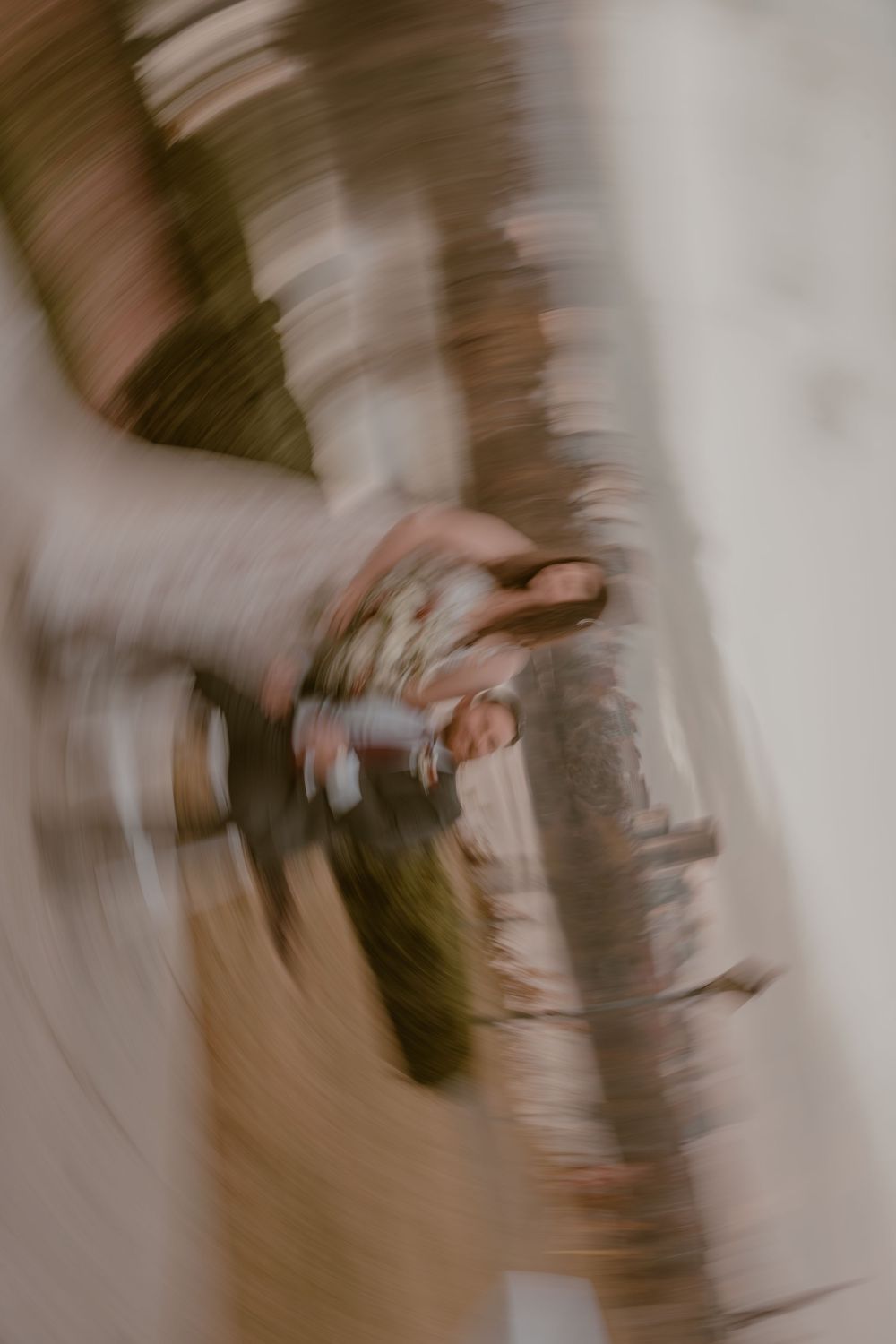 Abstract motion blur photography with swirling bokeh effect capturing figures in muted earth tones.