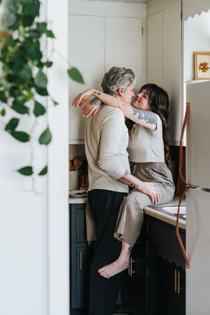 A sequence of three images showing a tender and intimate moment between two people against a white wall.