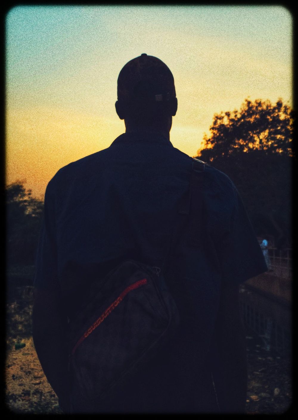 A silhouetted figure stands against a sunset sky in a series of sequential photos showing progressive darkening.