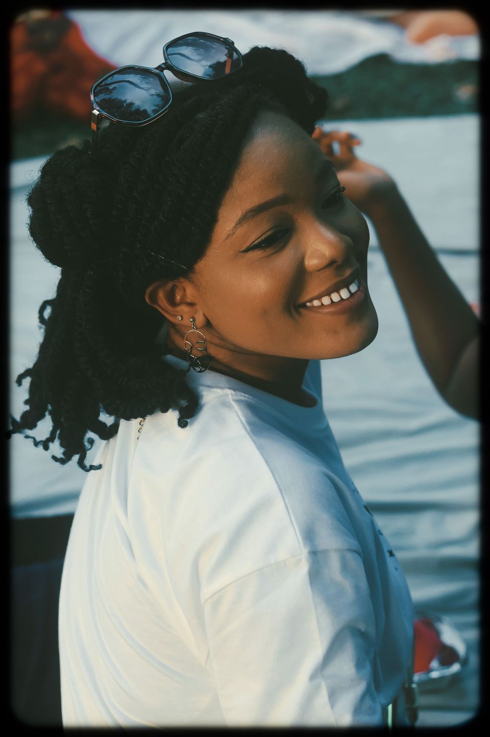 A series of candid shots showing someone in a white shirt laughing and enjoying a moment outdoors near water.