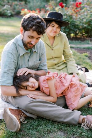 A relaxed family moment in a garden with blooming roses in the background.