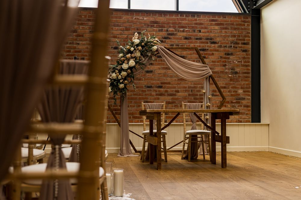 Modern wedding venue interior with exposed brick walls and elegant floral arrangements.