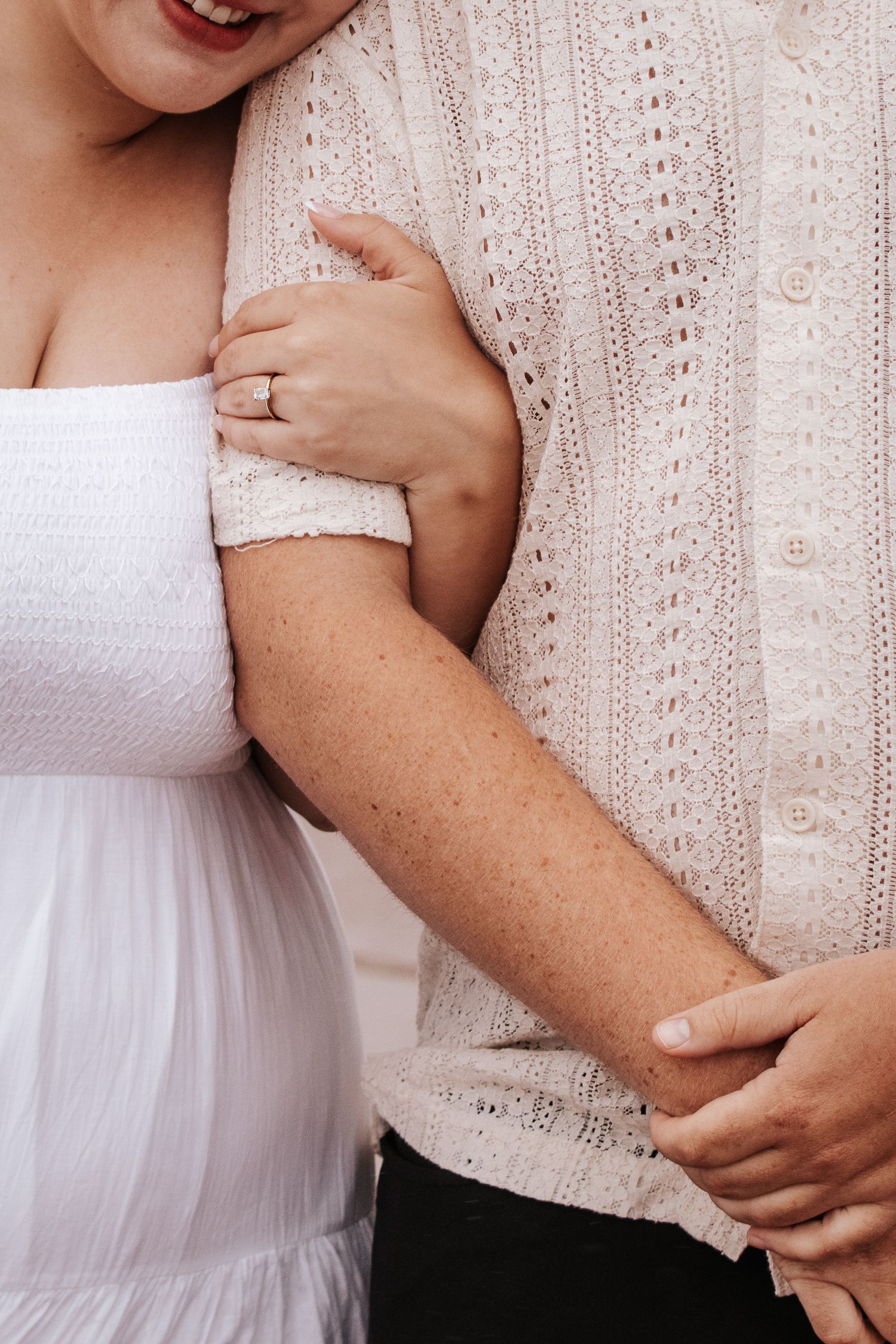 Close up detail of hands and lace on a white wedding dress. Photo at Charlottetown PE