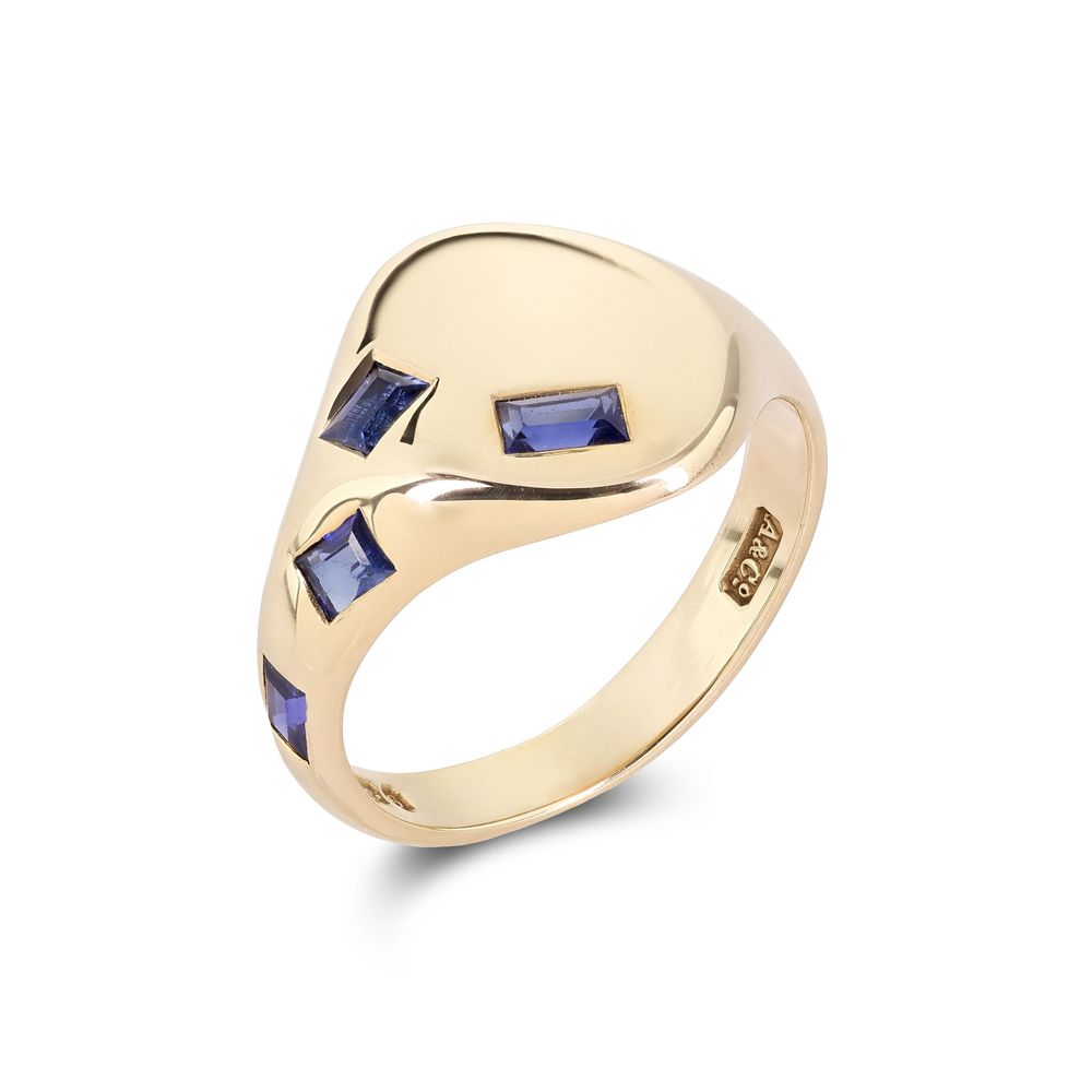 Gold signet ring with blue sapphire accents shown from multiple angles against white background.