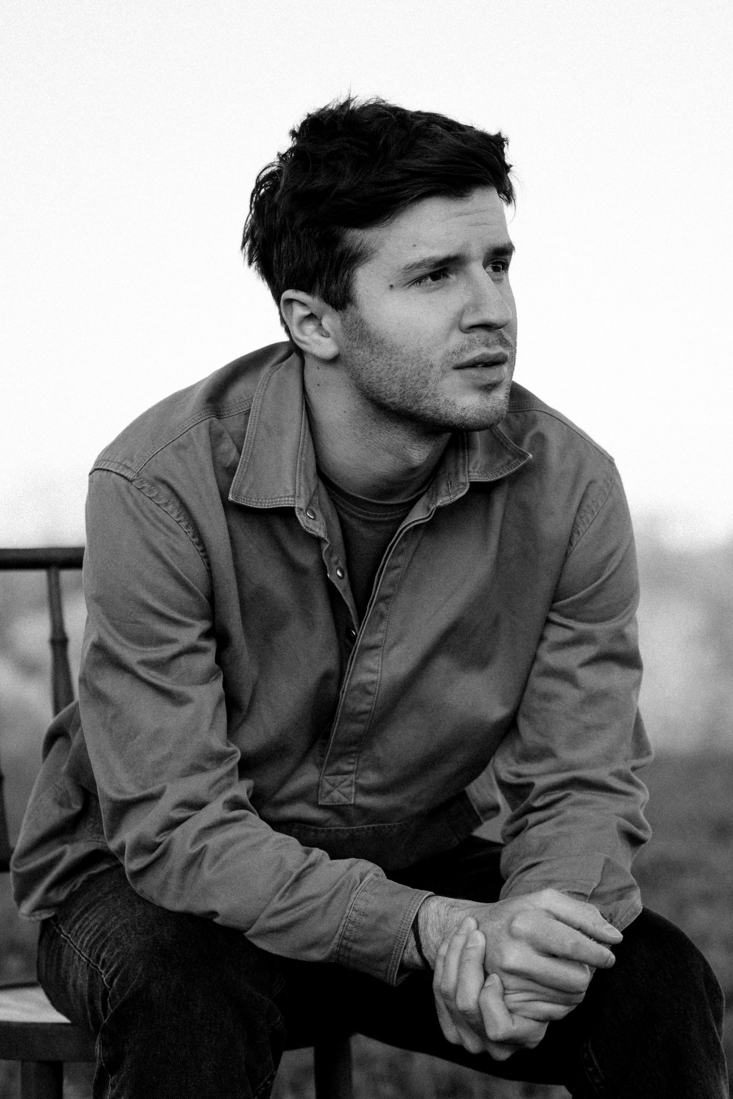 Black and white portrait of a person in casual attire looking to the side.