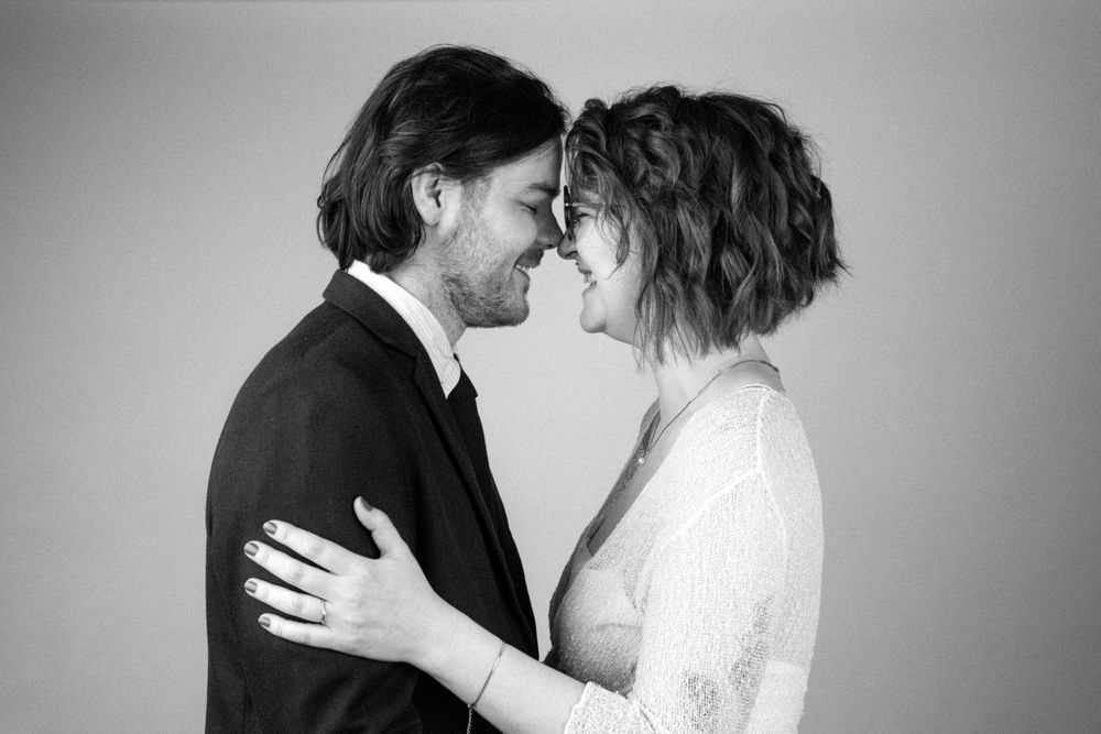 A series of romantic black and white wedding photos showing tender moments between a couple in formal attire.