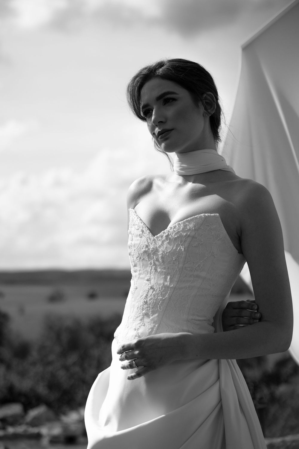 A classic black and white photo series featuring a bride in a strapless lace wedding gown against a soft, dreamy backdrop.