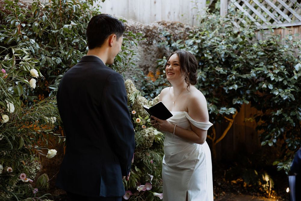 A romantic garden wedding moment captured with greenery and white lattice backdrop creating an intimate atmosphere.