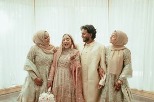 Wedding celebration with group wearing coordinated traditional attire in cream and beige tones.