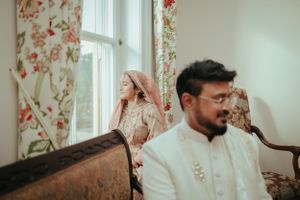Intimate moment captured in elegant room with floral curtains and classic furniture.