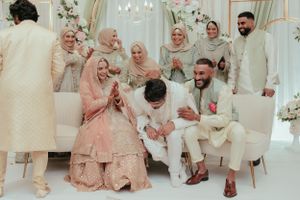 Wedding celebration showing guests in formal attire laughing together on elegant white seating.