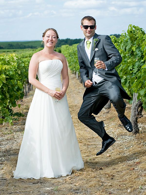 A couple leaps in a vineyard, celebrating their wedding day in the Chilterns, photographed by Abigail's Studio.
