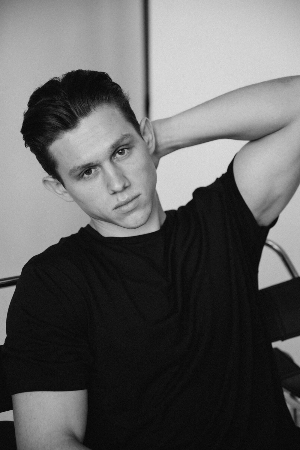 Black and white portrait in dark t-shirt with dramatic studio lighting.