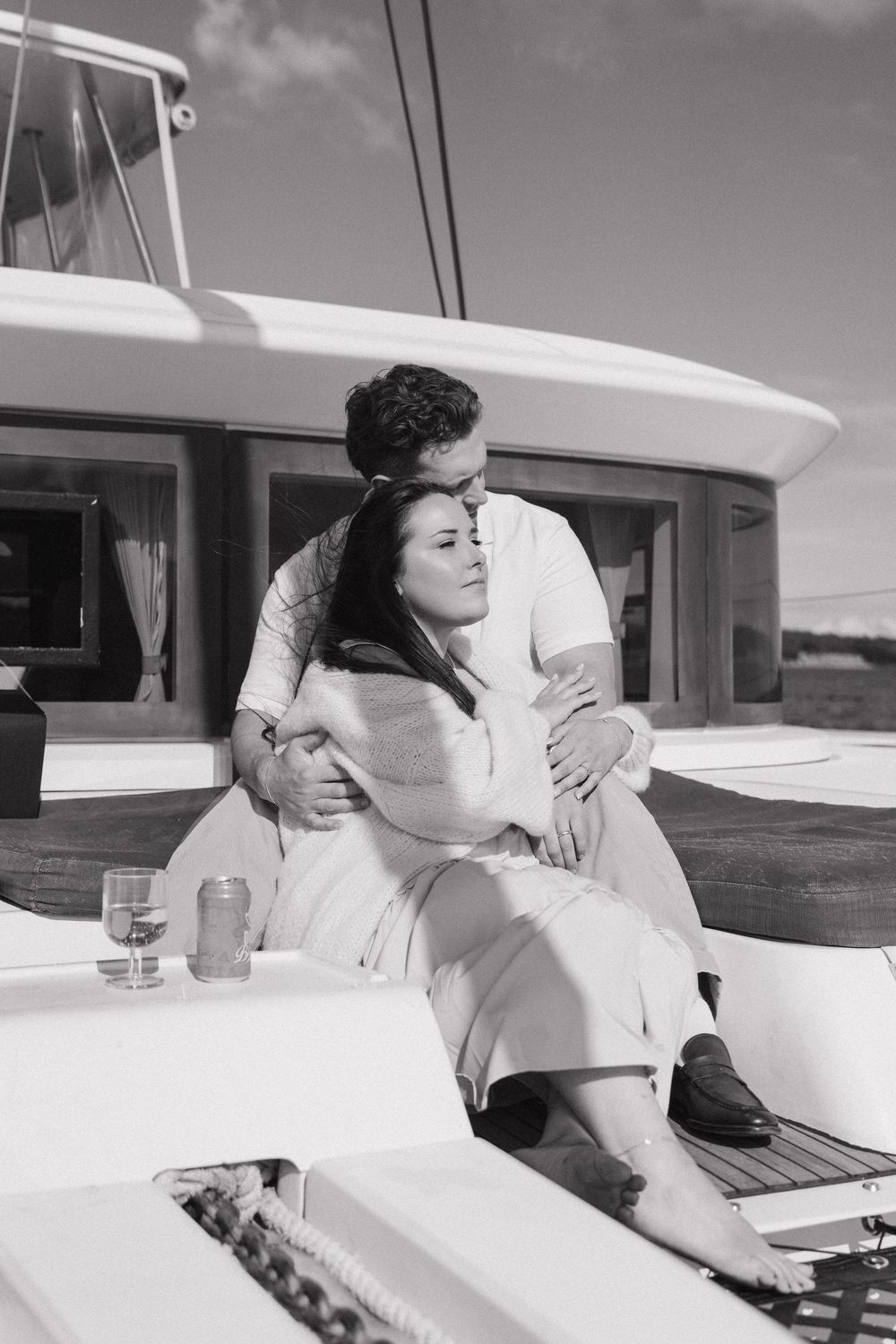 Couple embracing on a yacht deck in a romantic black and white photo in Halifax, Nova Scotia, Canada.