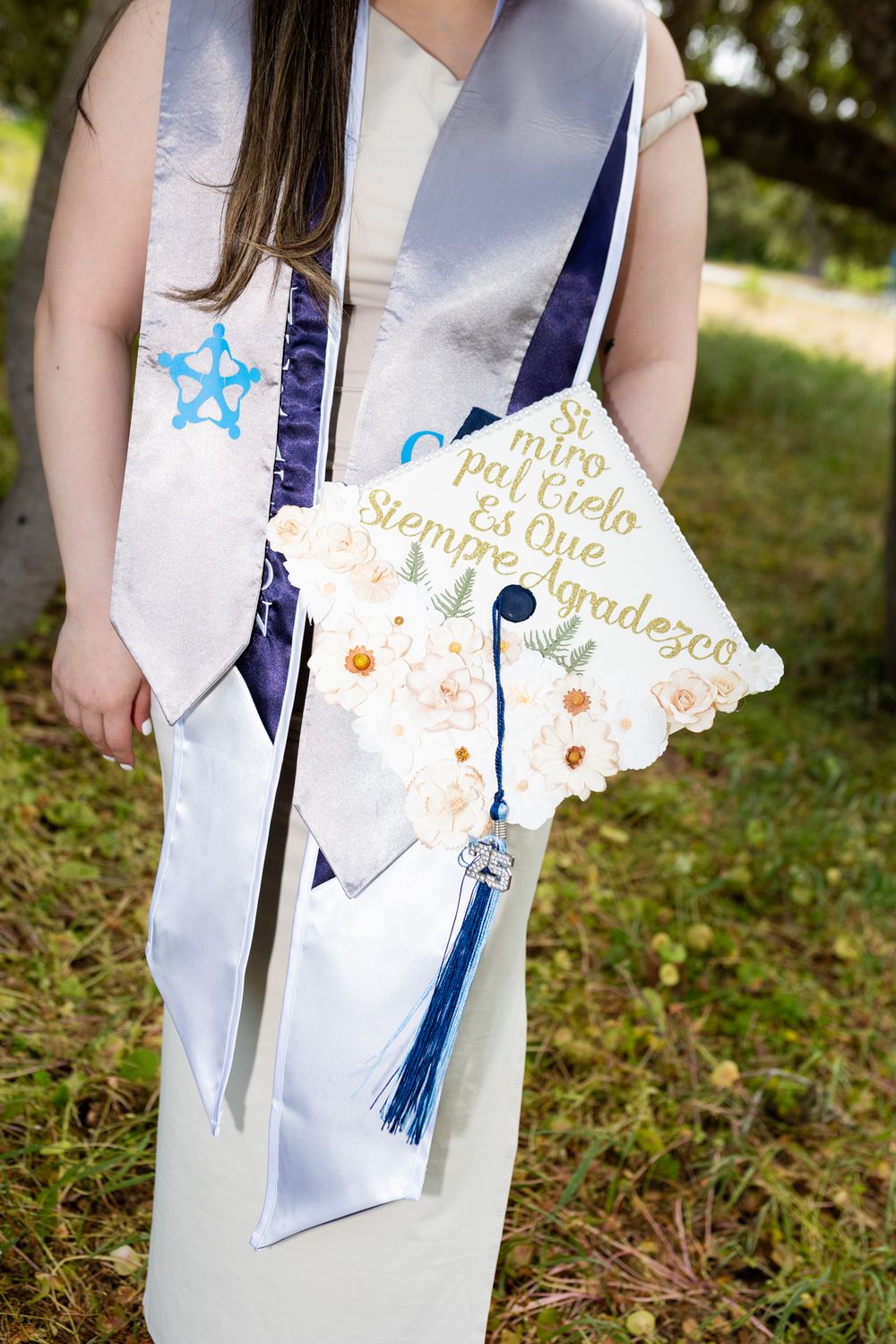 Close-up shots of a decorated graduation cap with blue tassel and gold lettering against a white background.