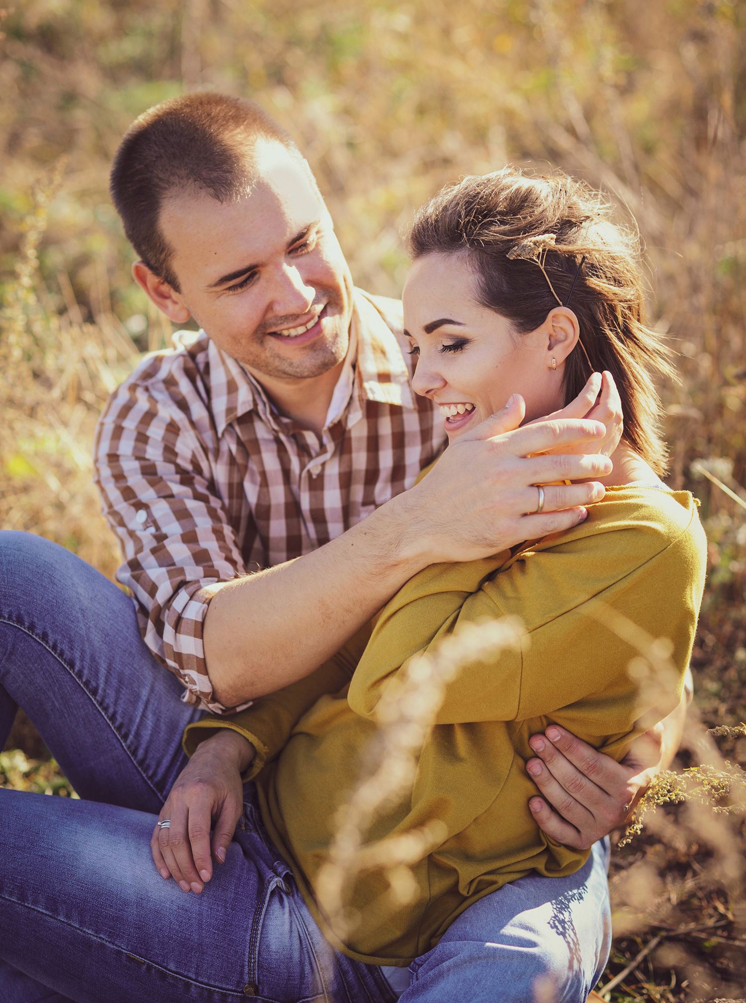Engagement picture of a happy couple having a happy time and relaxing on a lane in golden hour time.